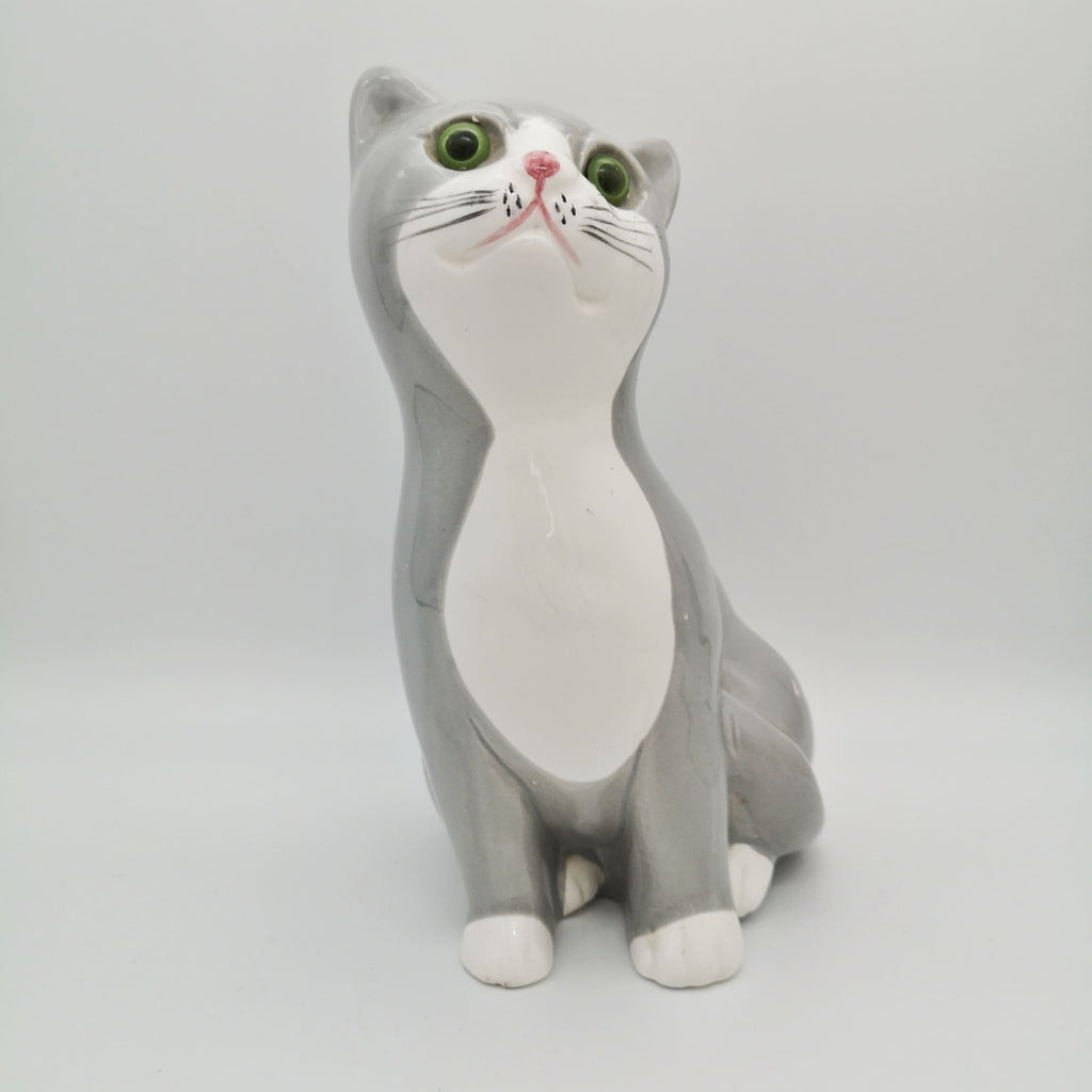 Sitzende weiß-graue Keramik-Katze mit grünen Augen