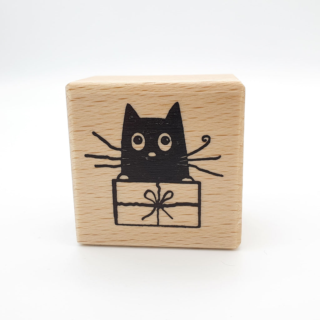 Stempel mit dem Motiv einer Katze, die in einem Geschenk sitzt