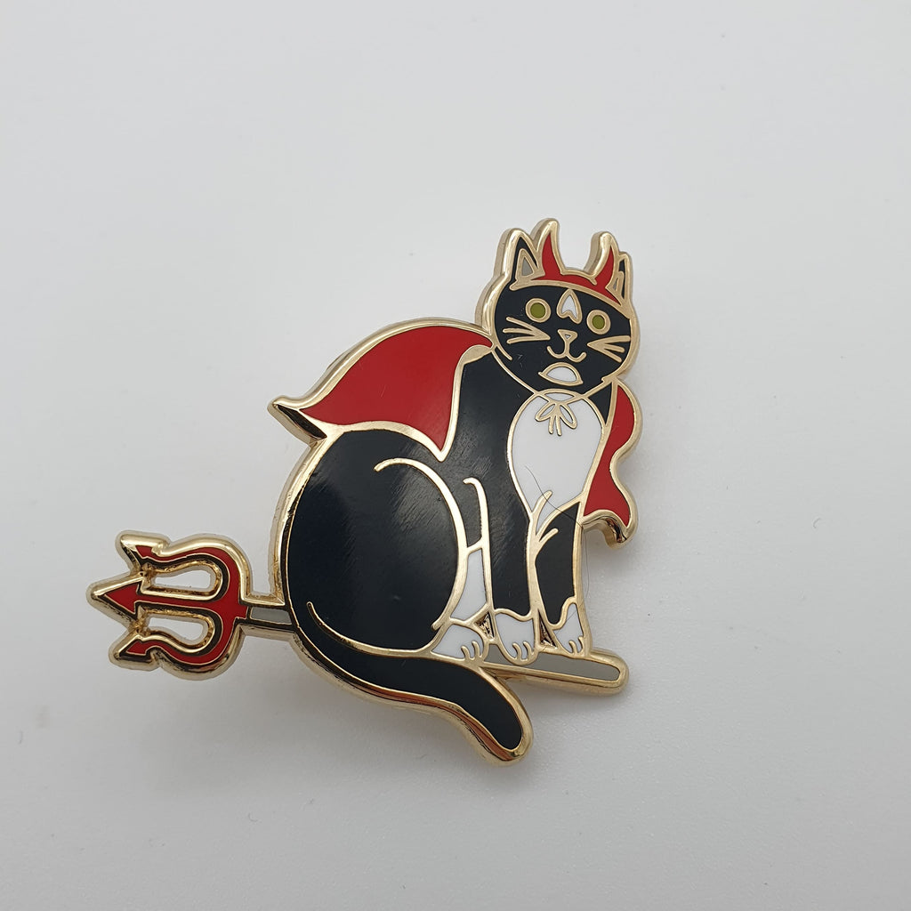 Pin in Form einer als Teufel verkleideten Katze, die auf einem Dreizack reitet