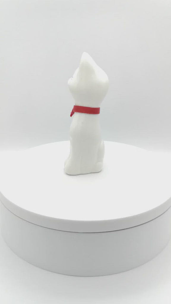 Weiße Katzenfigur mit roter Schleife