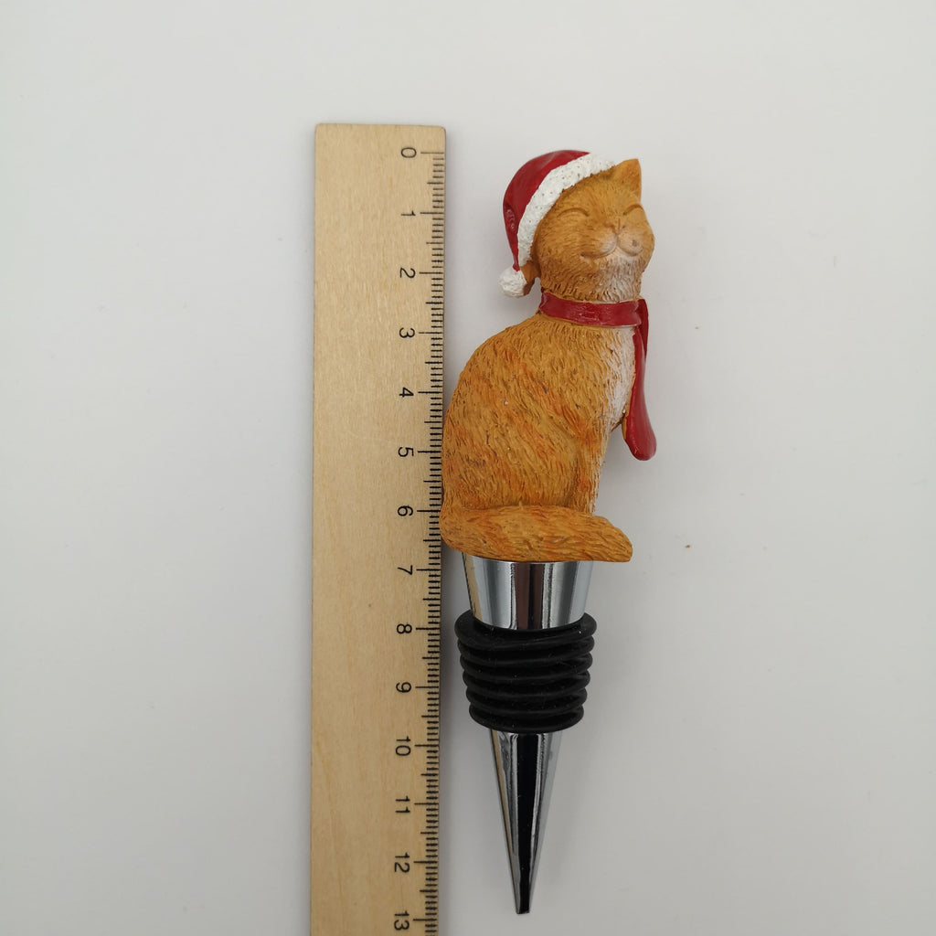 Flaschenstöpsel mit einer roten Katze, die einen roten Schal und eine Weihnachtsmütze trägt