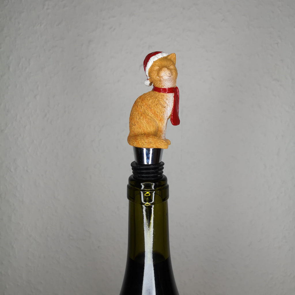 Flaschenstöpsel mit einer roten Katze, die einen roten Schal und eine Weihnachtsmütze trägt