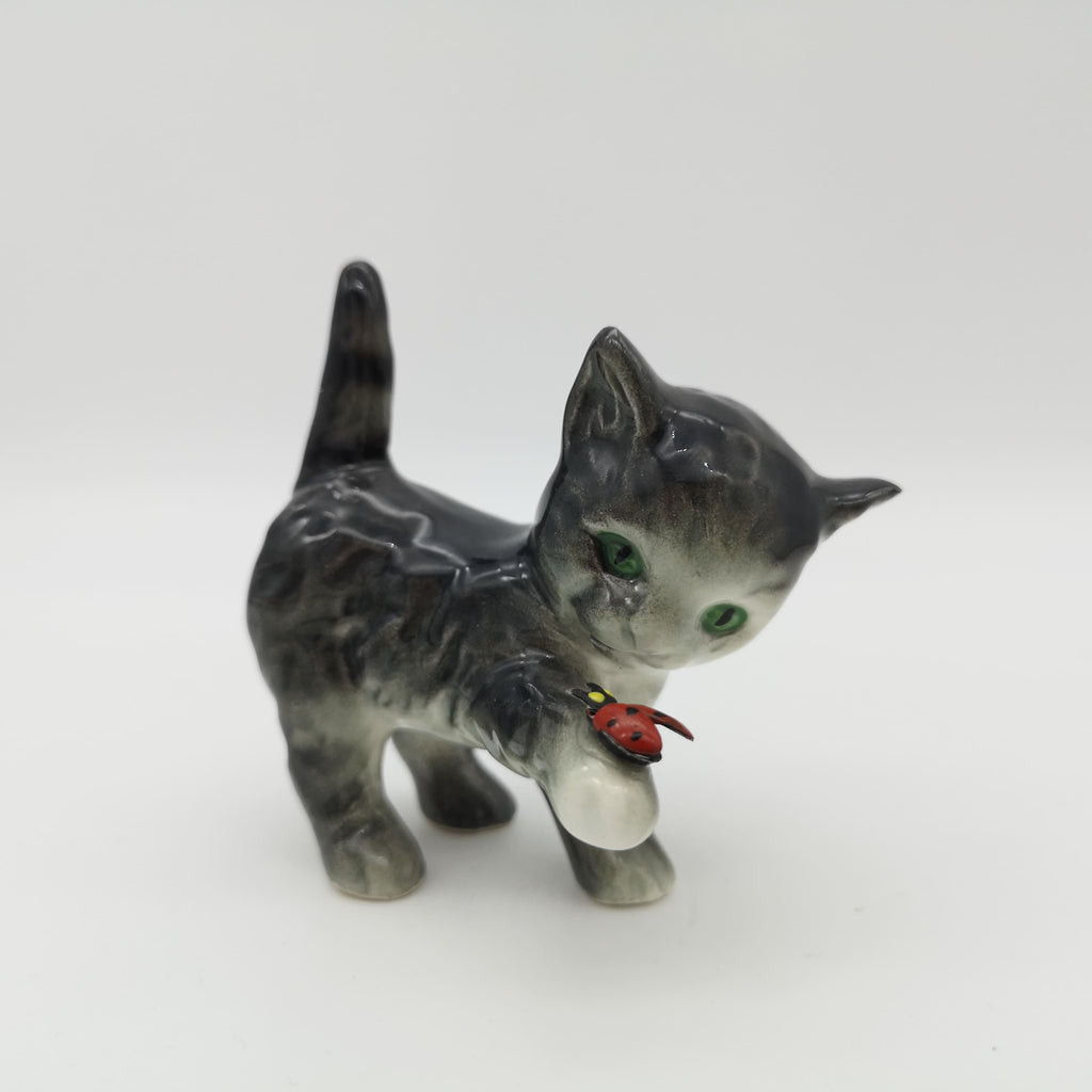 Porzellan-Katzenfigur mit einem Marienkäfer