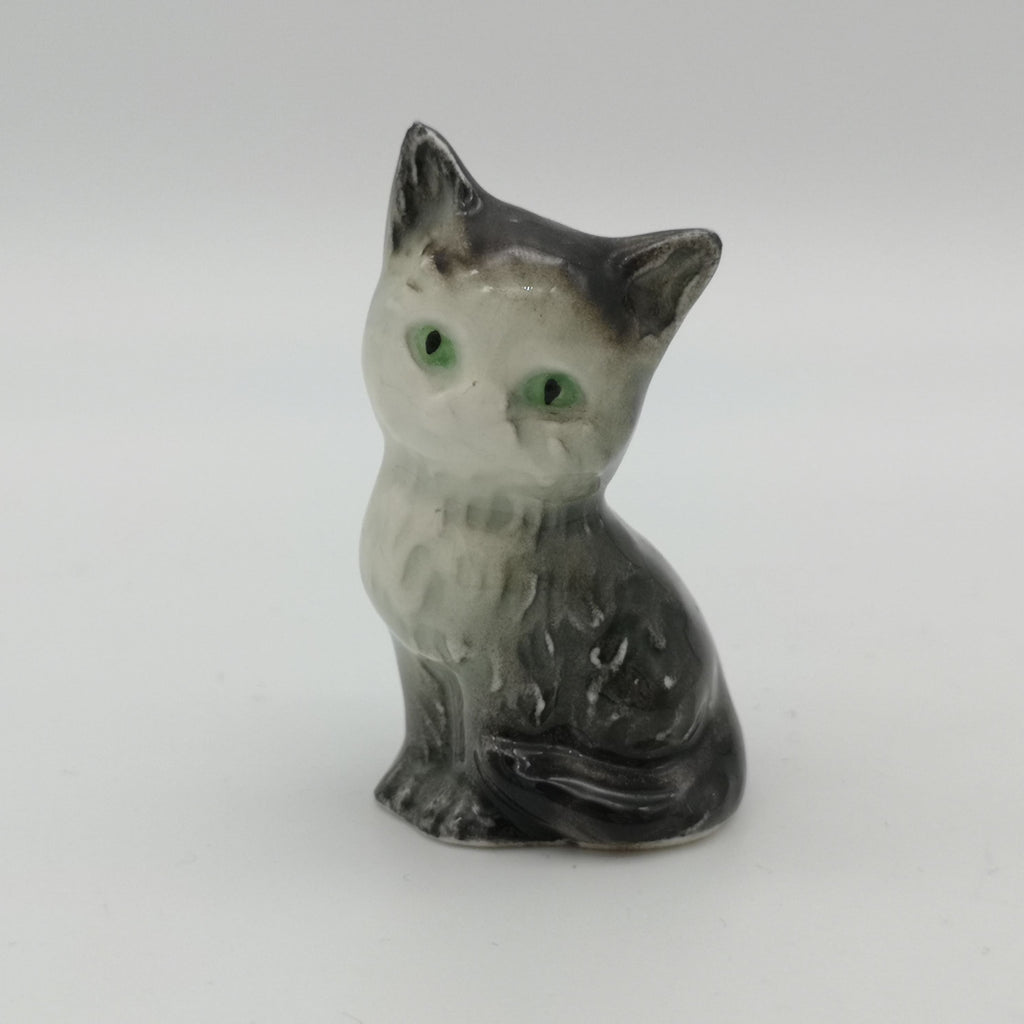 Graue Porzellan-Katze mit grünen Augen