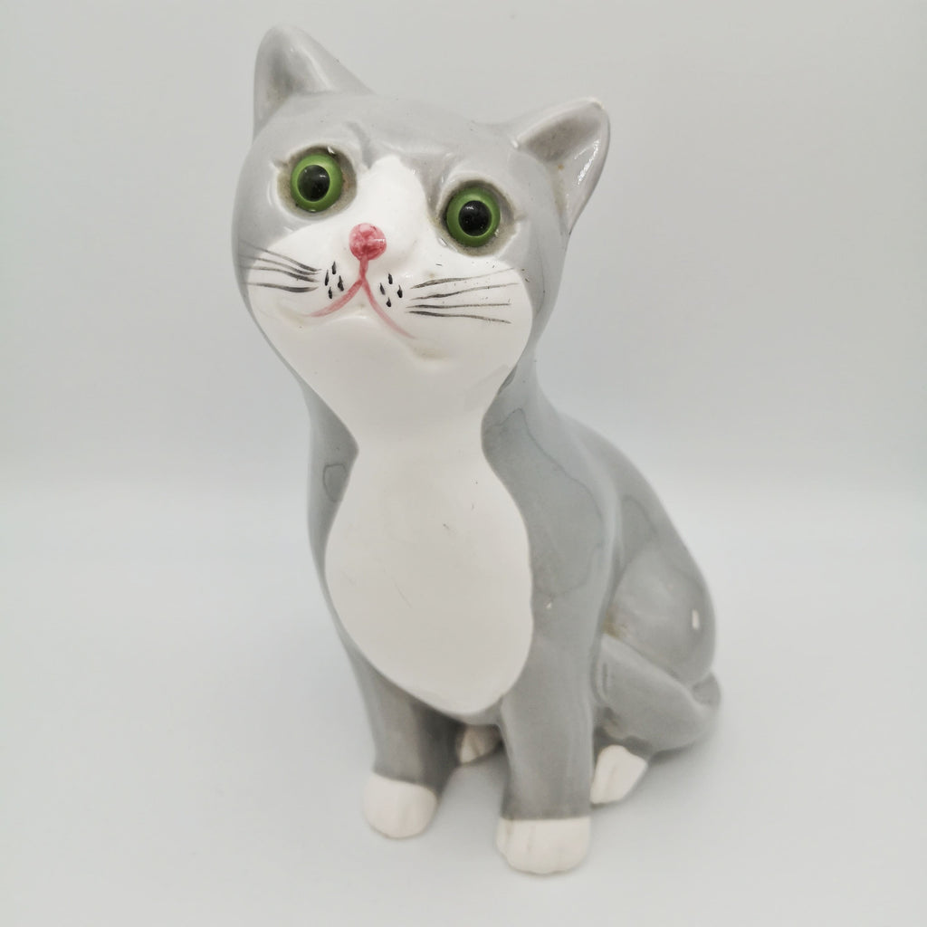 Sitzende weiß-graue Keramik-Katze mit grünen Augen
