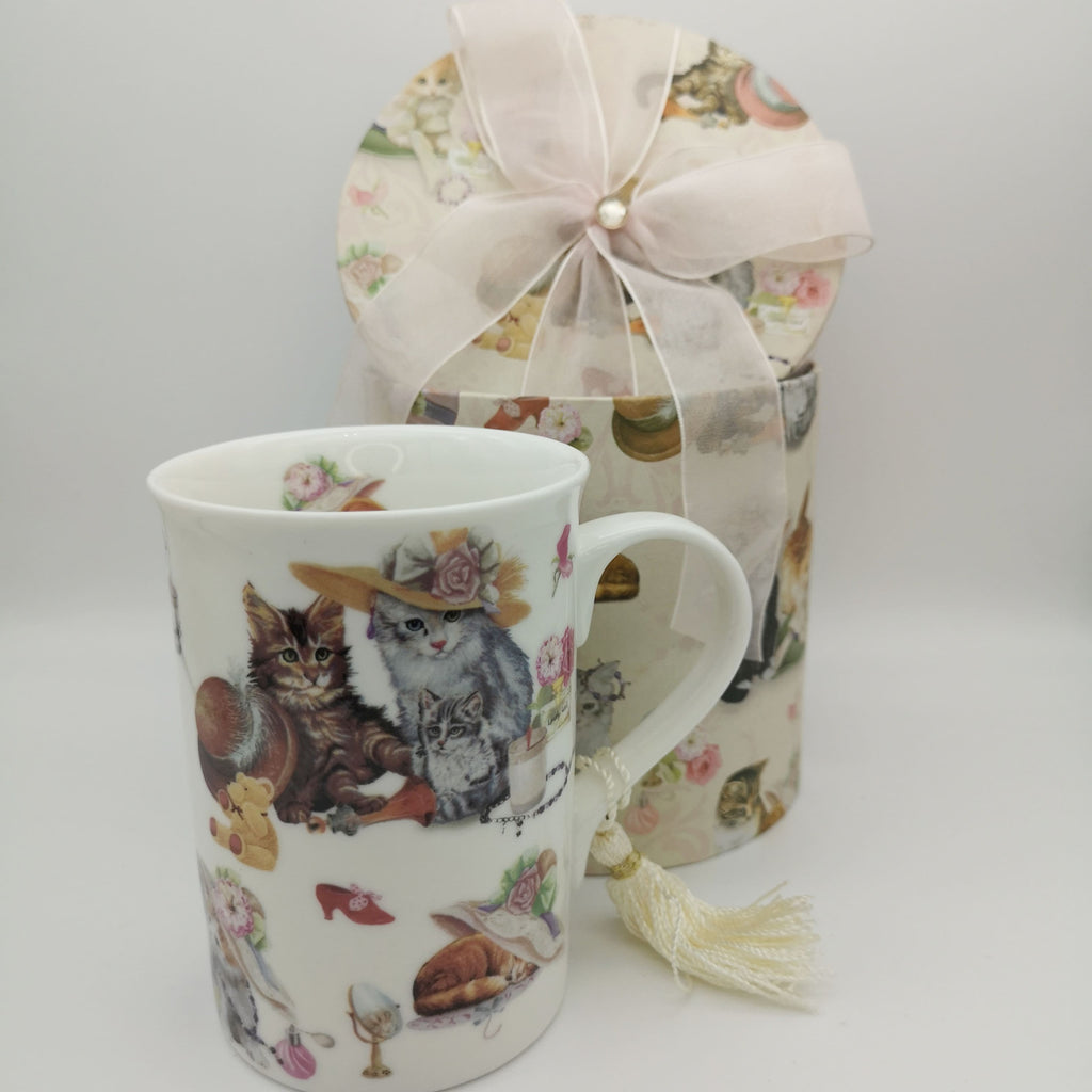 Porzellan-Tasse mit Katzenmotiven und einer Box mit rosa Schleife