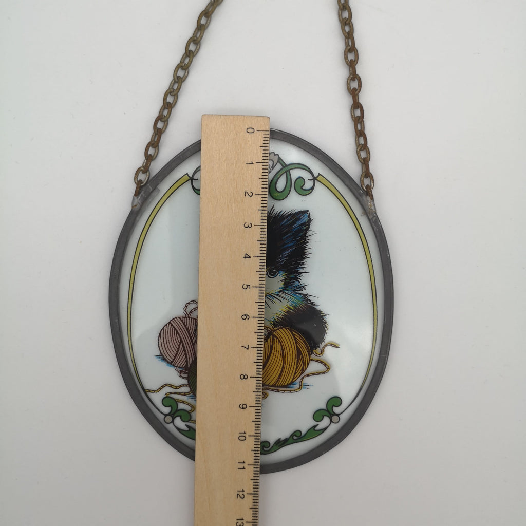 Vintage-Fensterbild mit einem Katzenmotiv und Kette in einem Zinnrahmen und Lineal