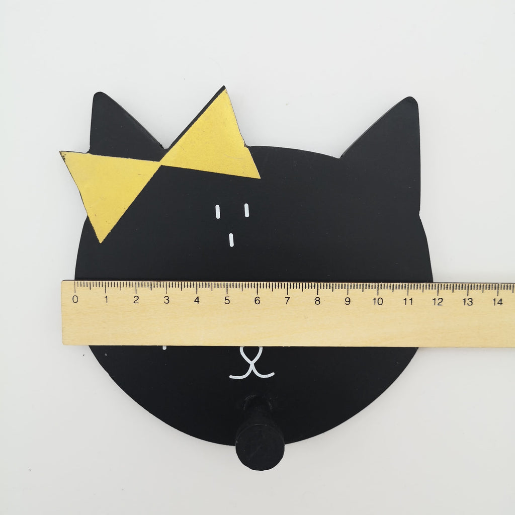 Wandhaken in Form eines schwarzen Katzenkopfes mit einer gelben Schleife